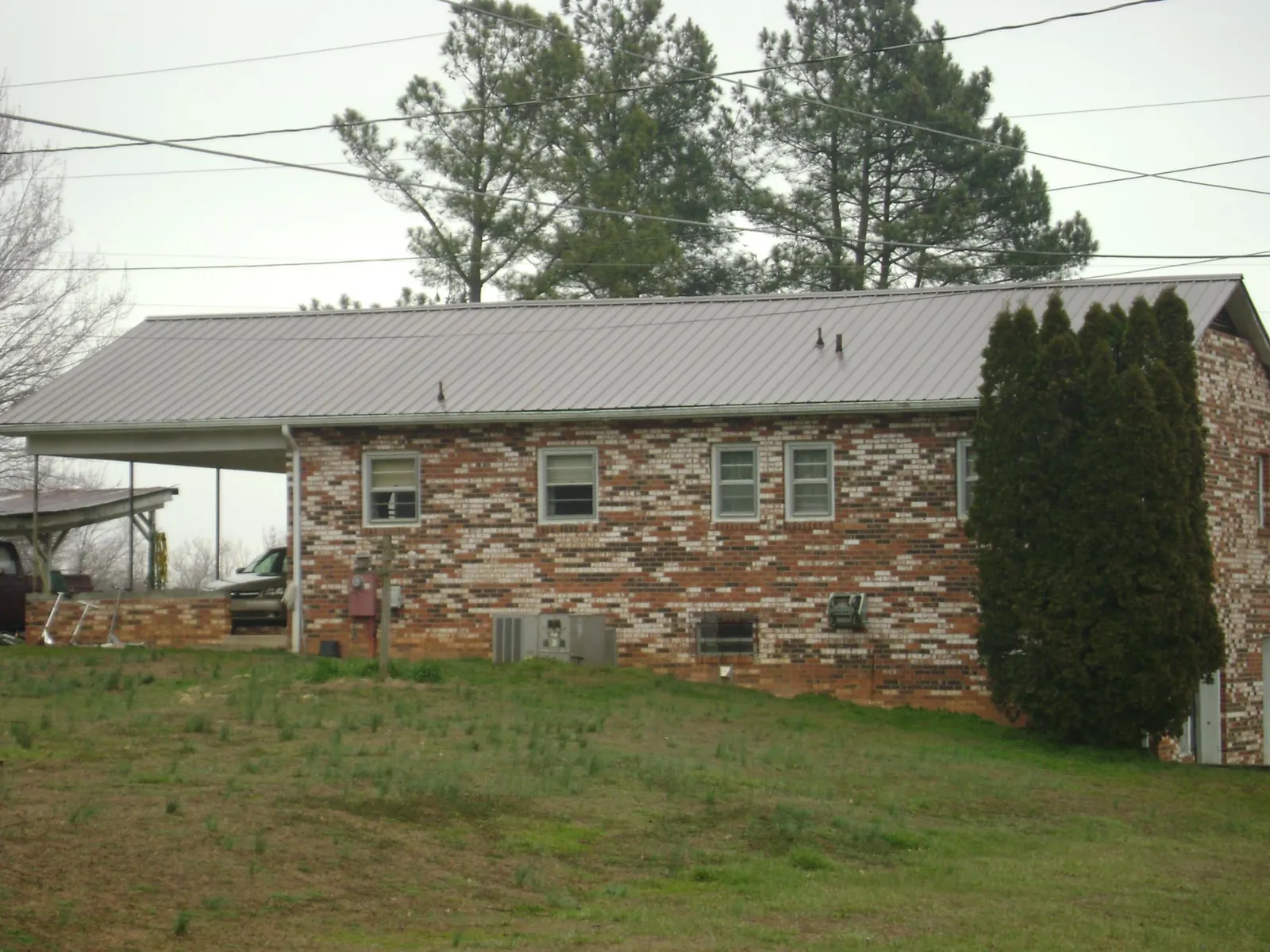 Gray metal roof on a brick split level home with a carport in Plymouth